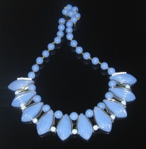 Image shows a pale blue plastic beaded statement necklace, made with a front row of large dagger drop shaped beads, with smaller round beads either side